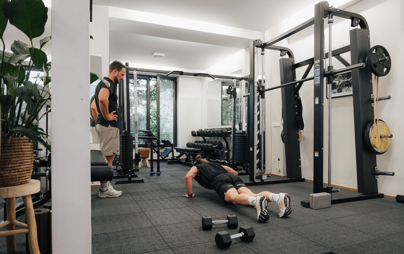 Trainer korrigiert Übungsausführung im Aufbauplan der Sporttherapie im Loft42 Stuttgart